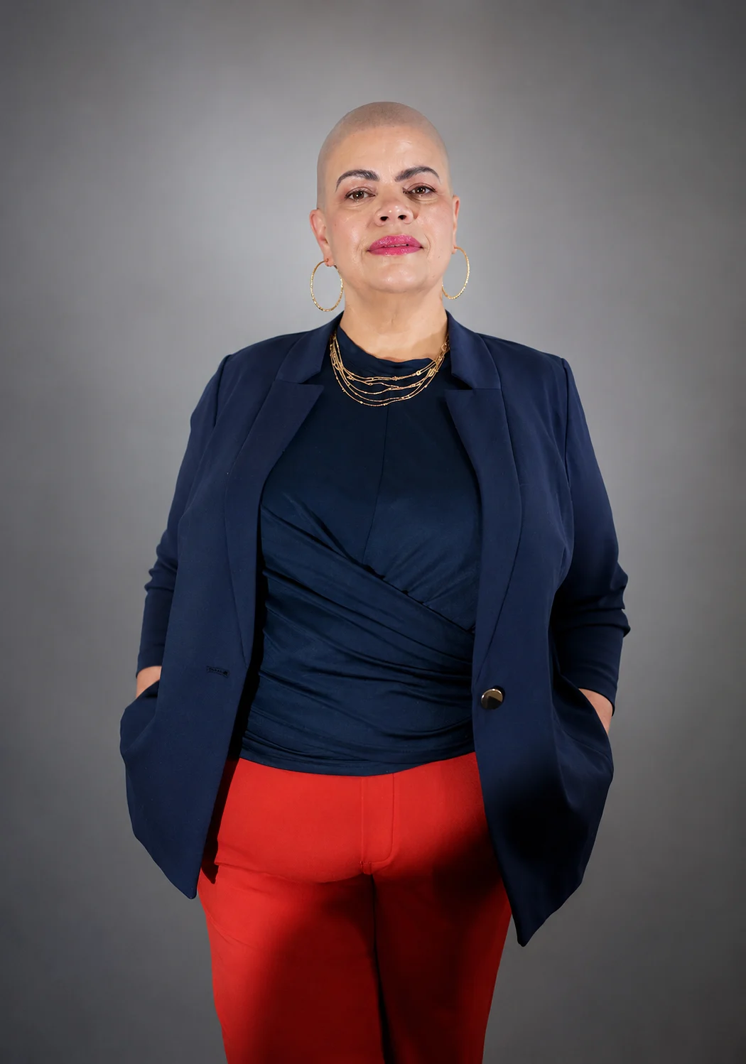 Hands in pockets, red trousers, grey studio