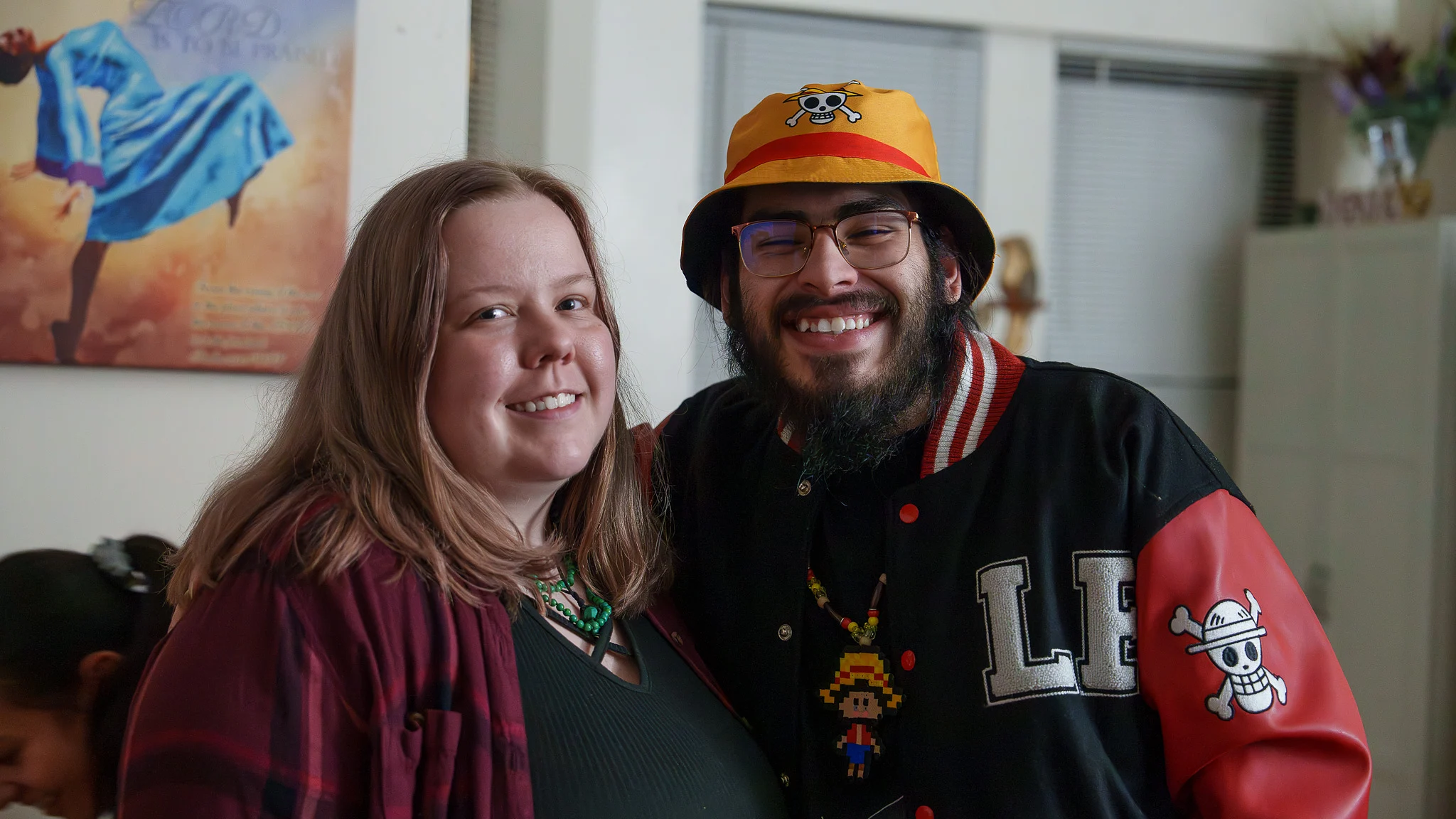 A couple in the doorway, bucket hat and letterman jacket