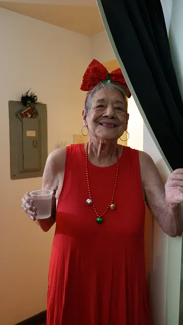 A woman in red at the door, drink in hand