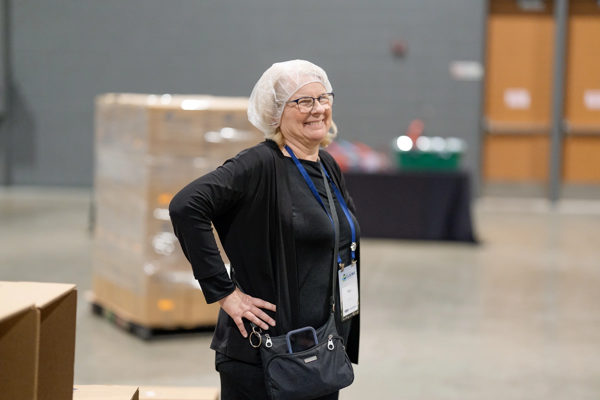 A volunteer in a hairnet by the pallets