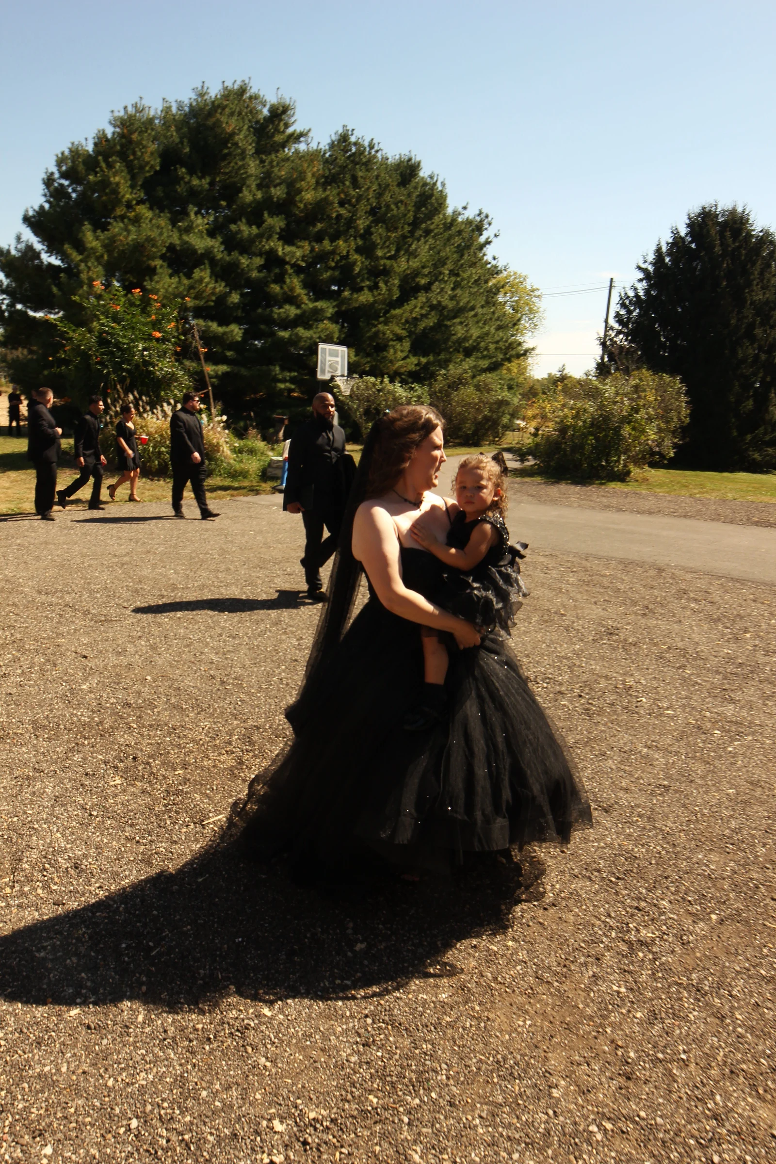 The bride carrying her daughter up the drive