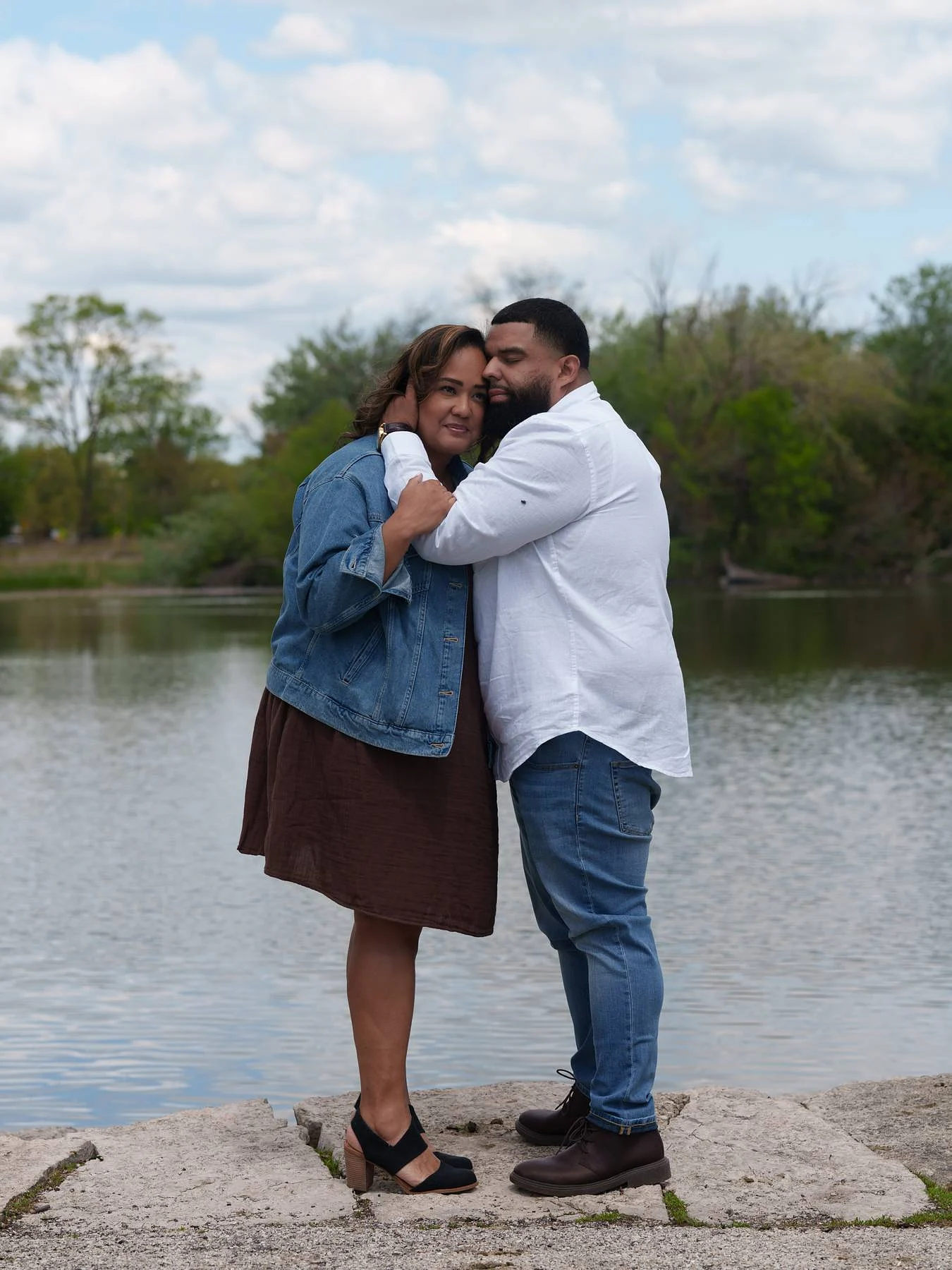 Her arms around his neck on the rocks
