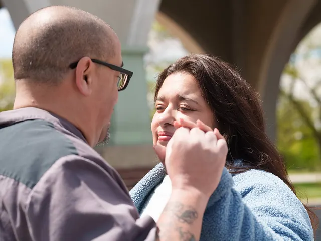 He brushes her cheek