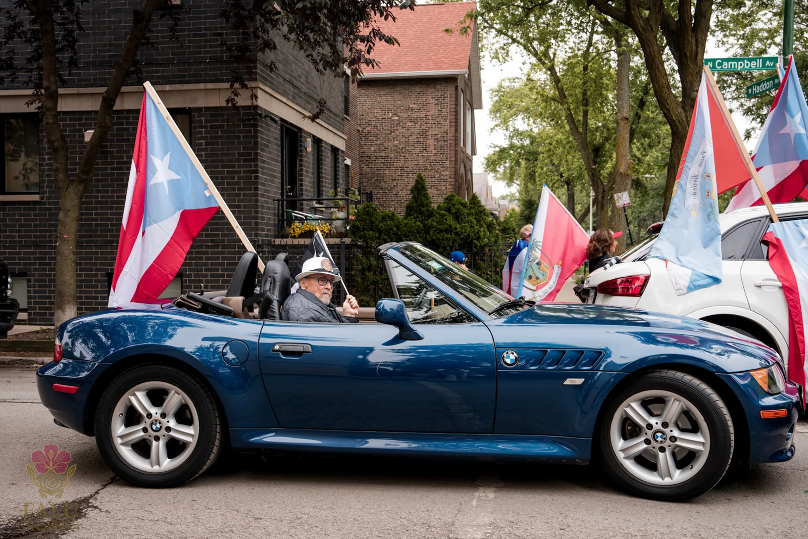 A blue convertible carrying Puerto Rican flags through the parade.