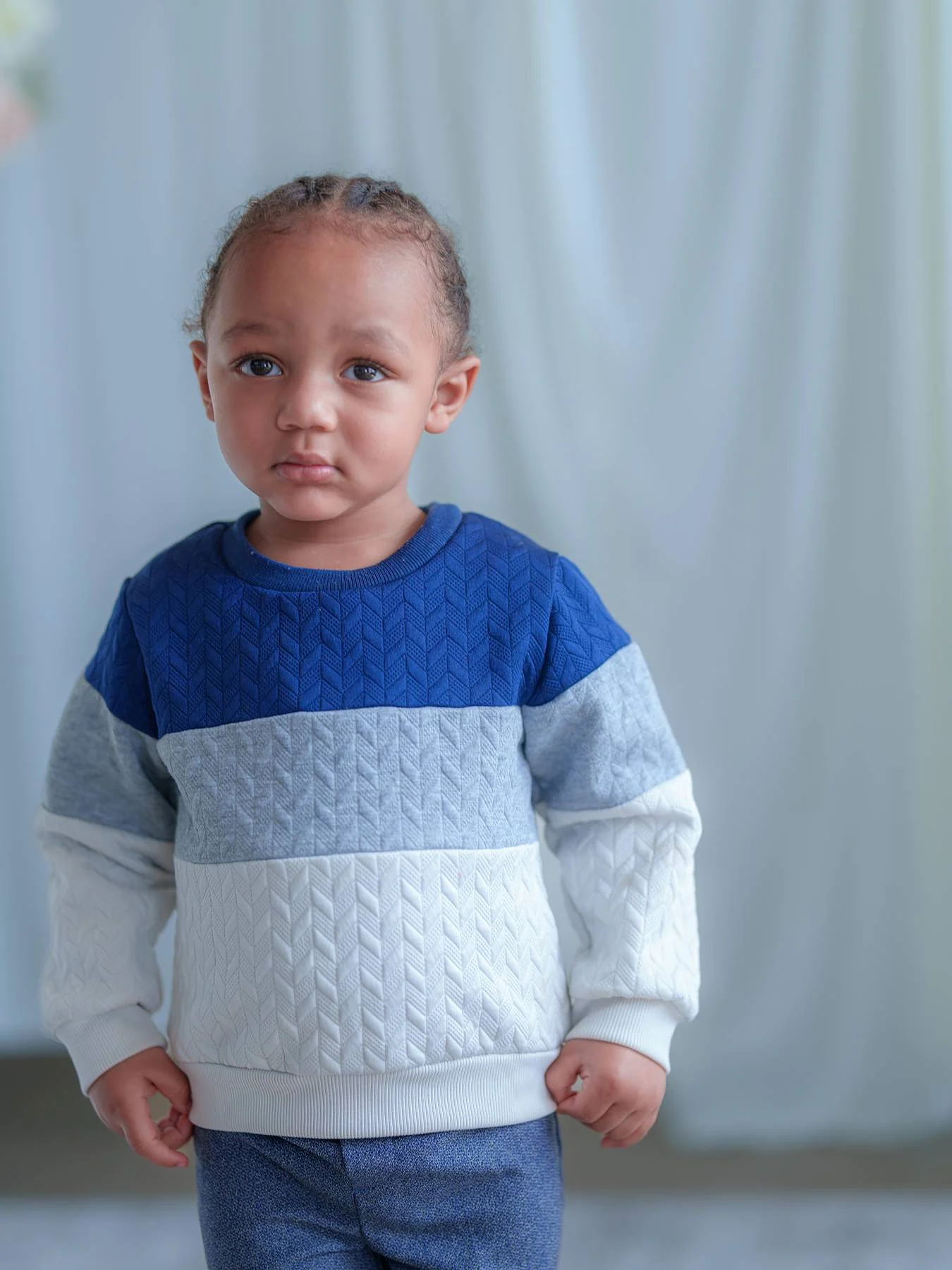 A small boy in a blue sweater