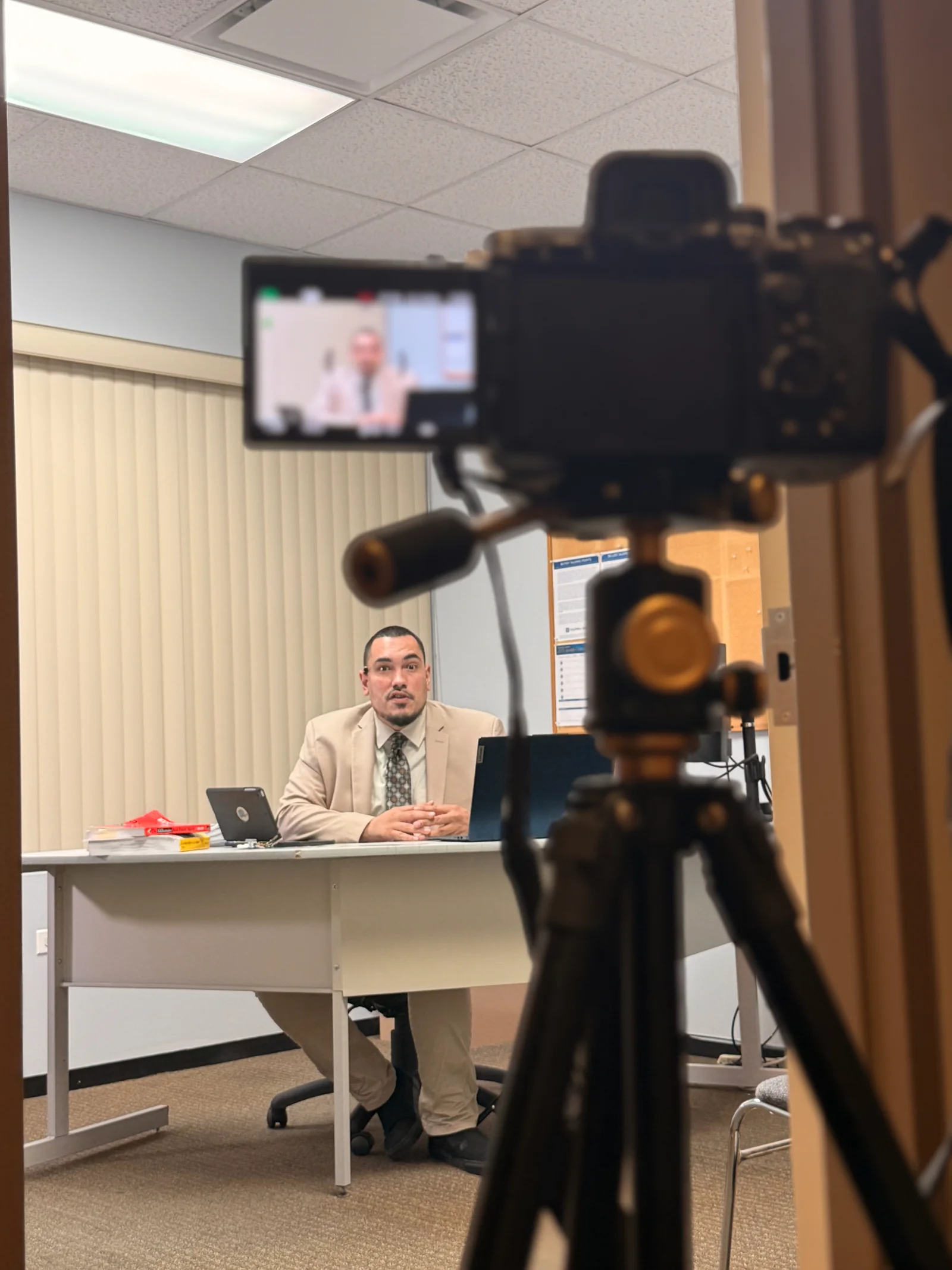 Sony camera and its flip-out screen frame Kon seated at a desk during a shoot