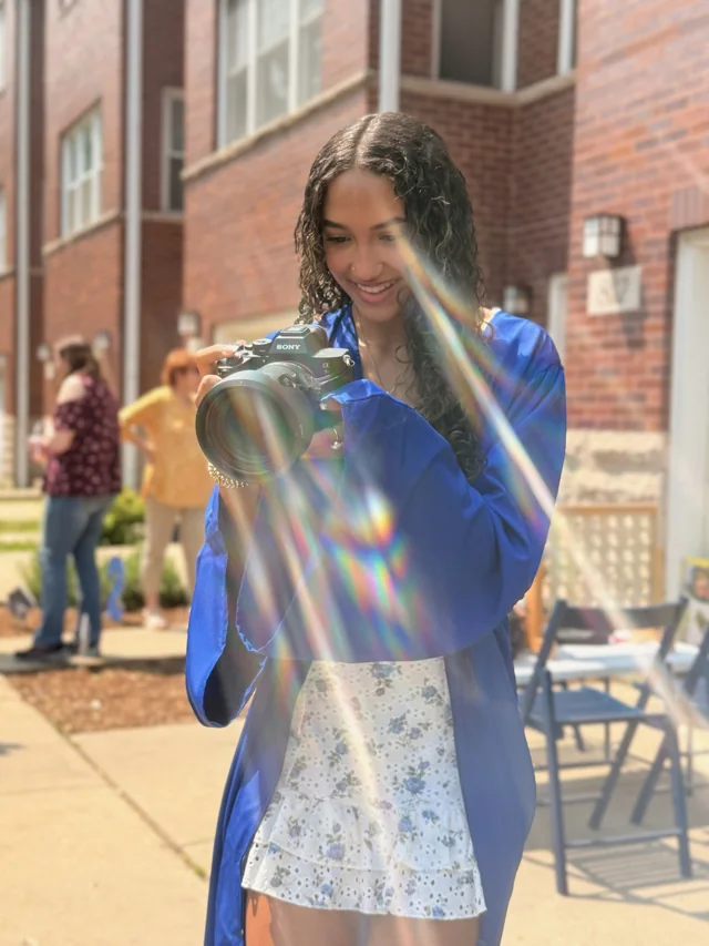 A client in a blue jacket holding Riri in the sunlight
